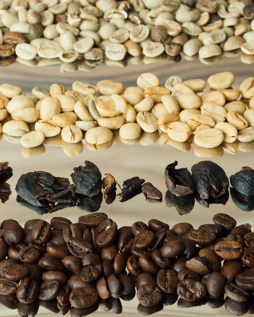 Plusieurs types de grains de cafés posés sur une table.